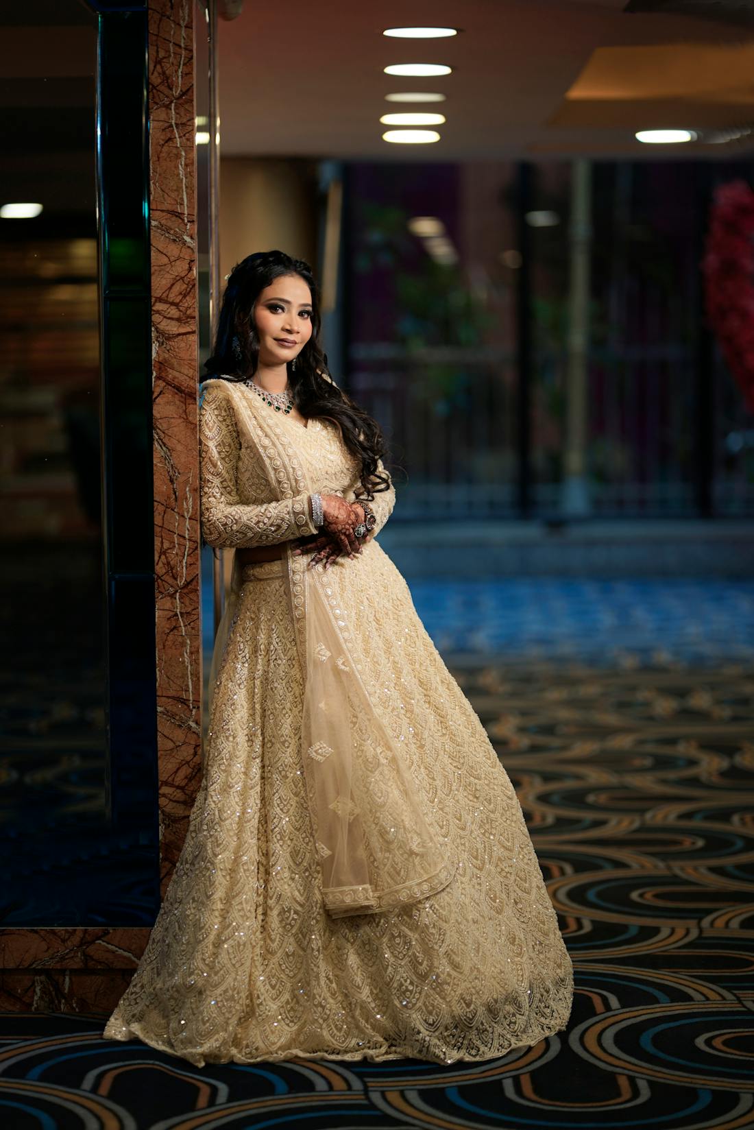 Indian bride in an embellished champagne reception lehenga with structured shoulders
