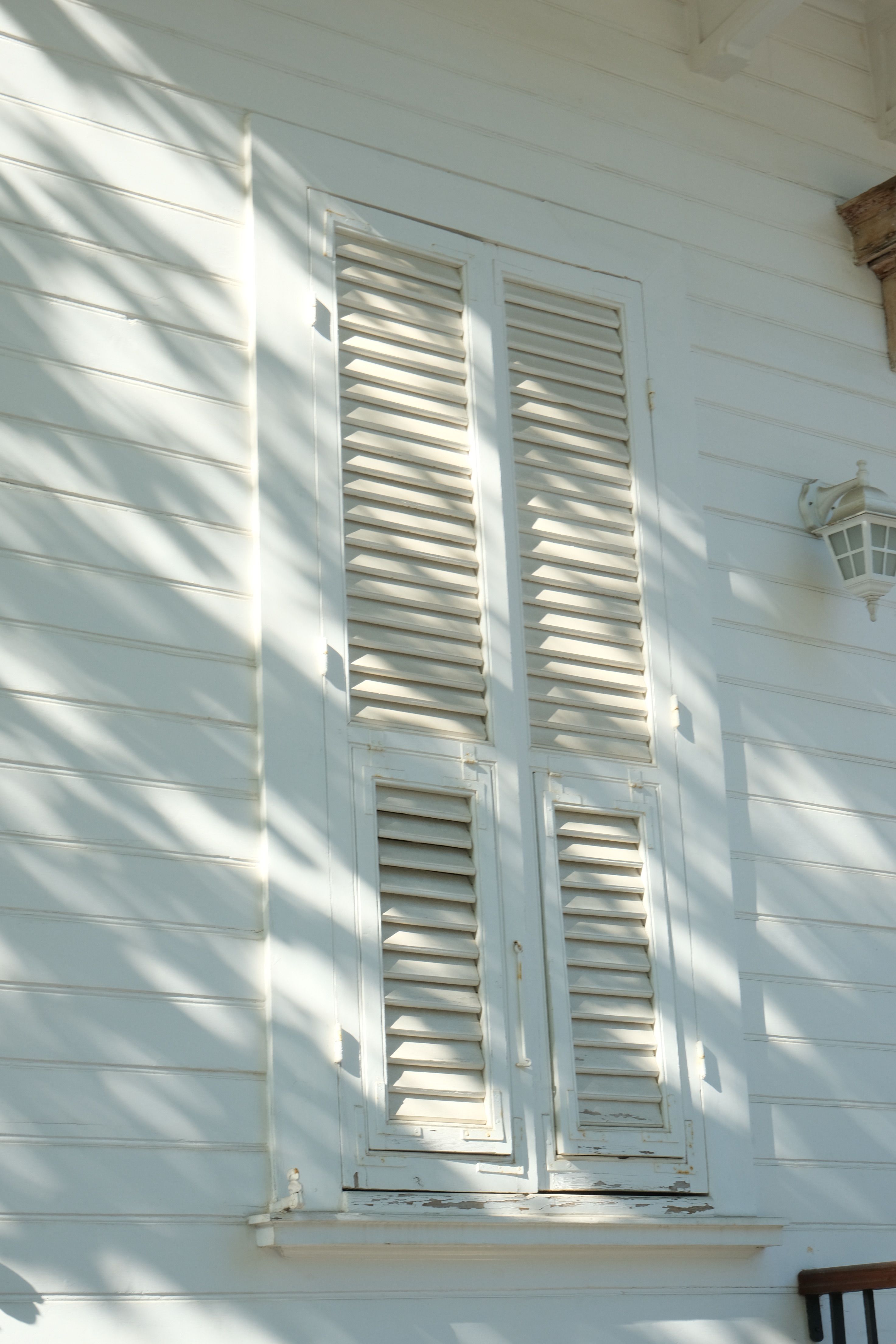 Charming white shutters with sunlit shadows on a Heybeliada home, Istanbul.