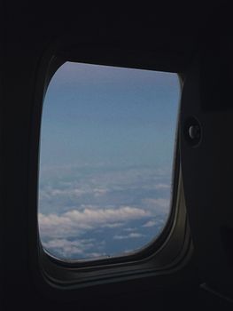 A picturesque view of clouds and sky seen through an airplane window during flight.