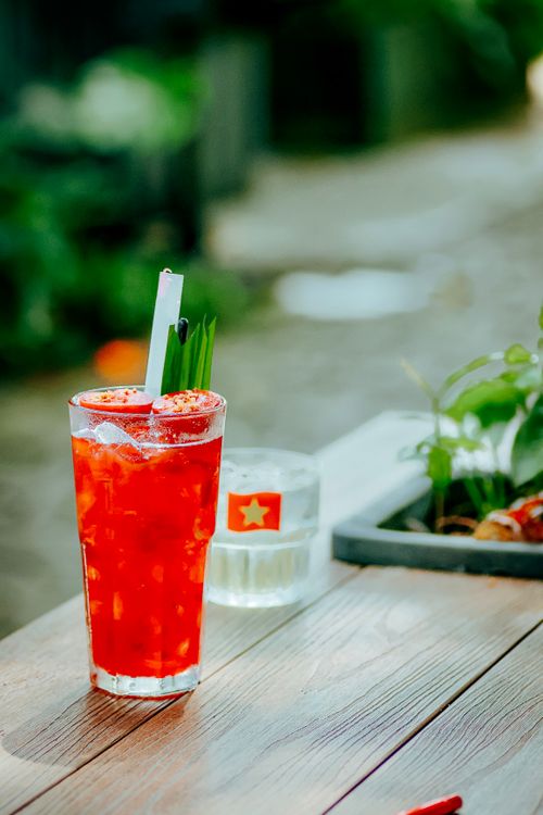 Free Bright red fruit drink with ice on wooden table outdoors. Perfect for summer. Stock Photo
