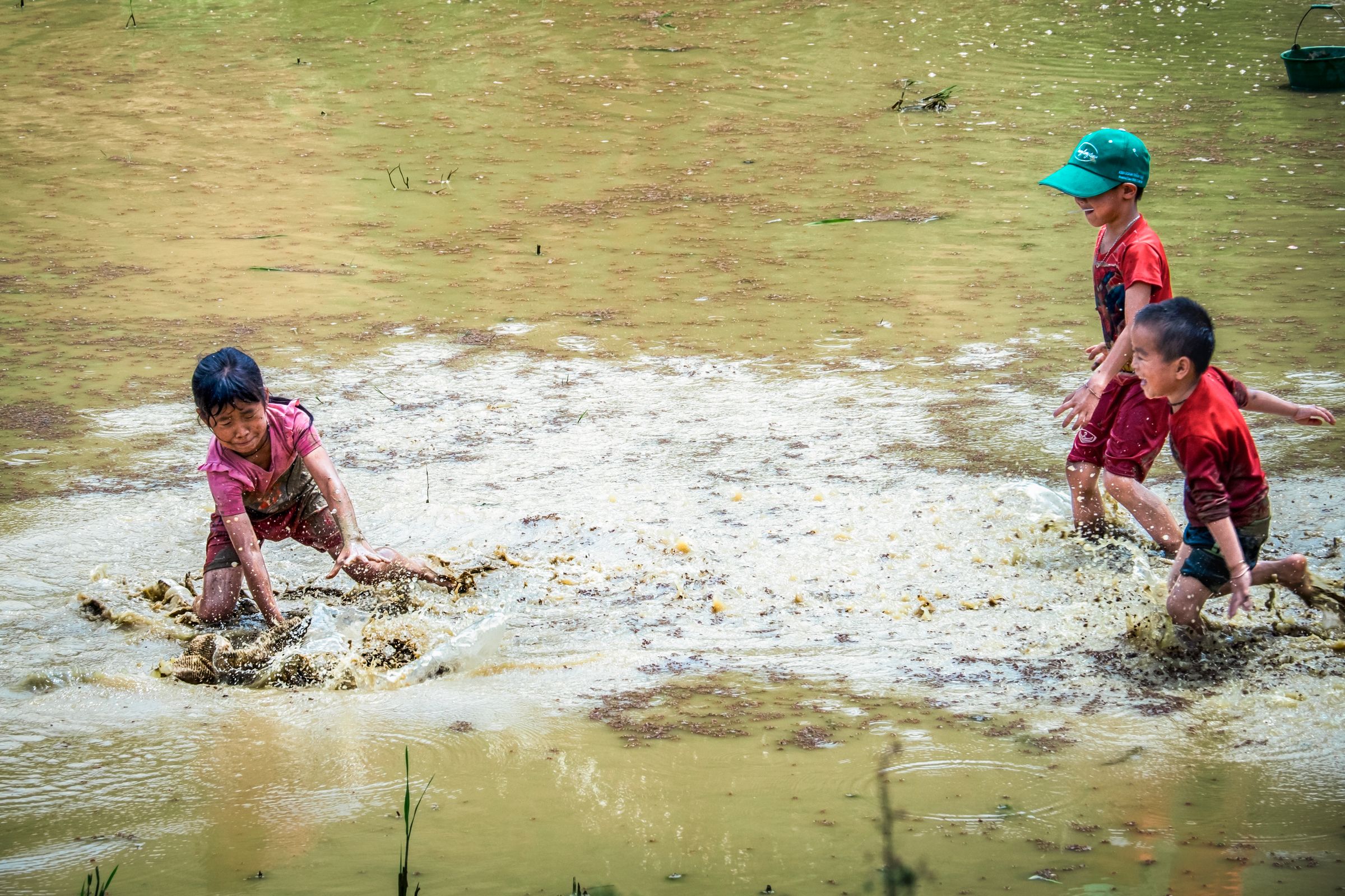 Bambini che giocano insieme nell'acqua e nel fango