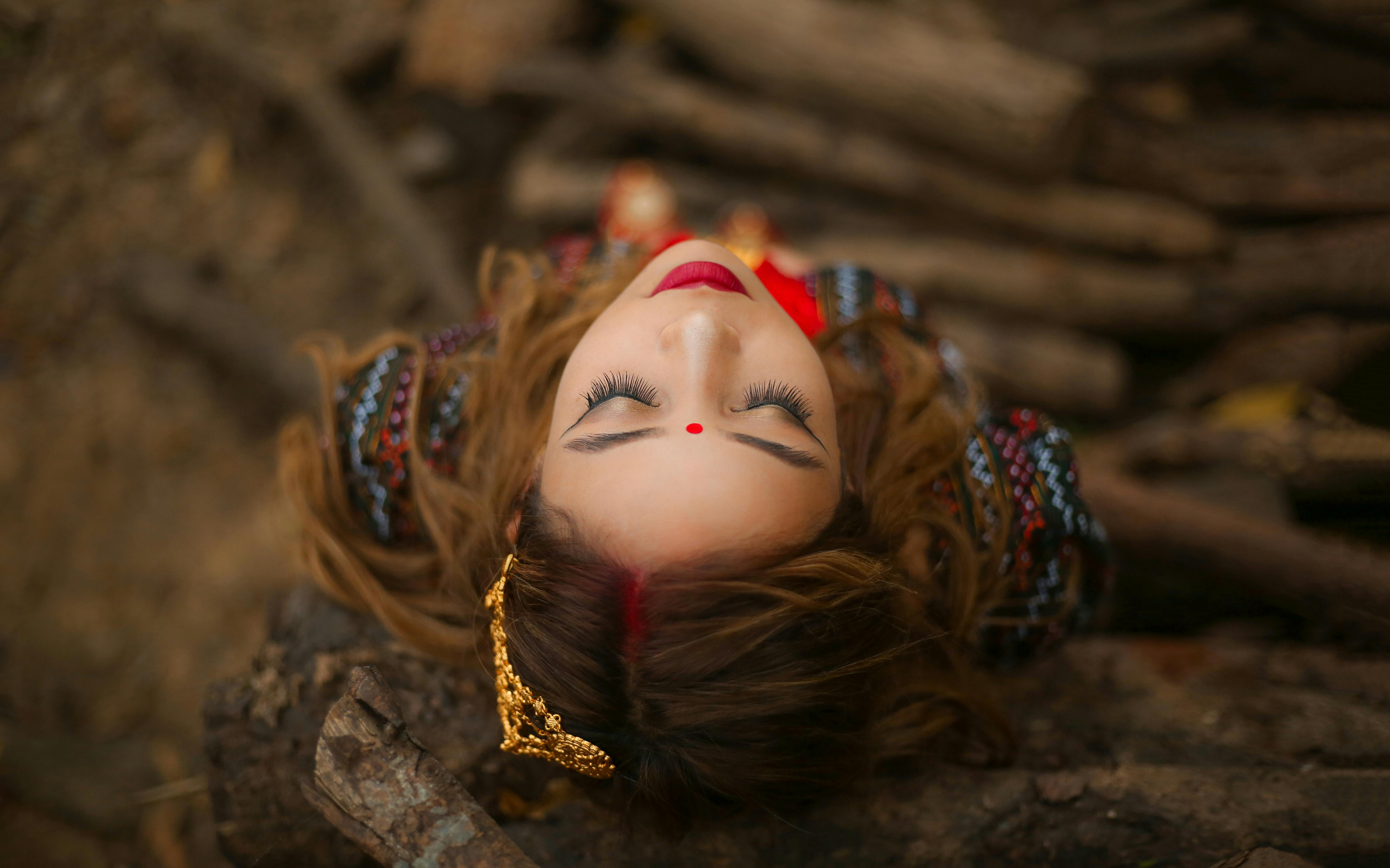 一位身着传统服饰的女子，从艺术角度拍摄的头顶镜头中，神情平静