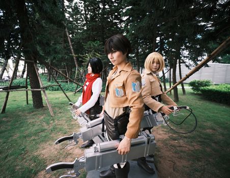 Diverse group of cosplayers posing in character outfits in an outdoor forest area.