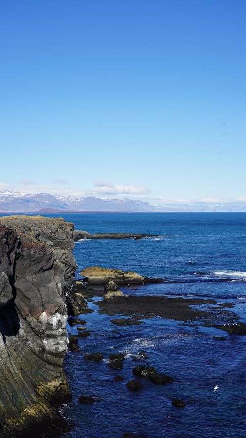 Free Stunning view of Iceland's rugged coast and blue seas on a clear day. Stock Photo