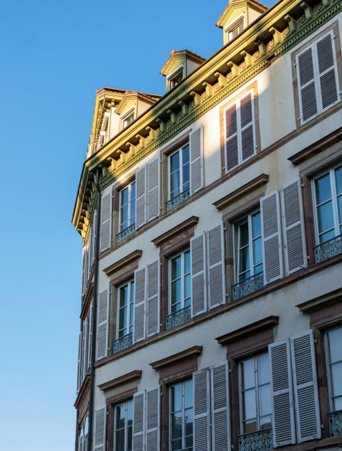 Elegant historic building facade in Strasbourg, France with clear blue sky.