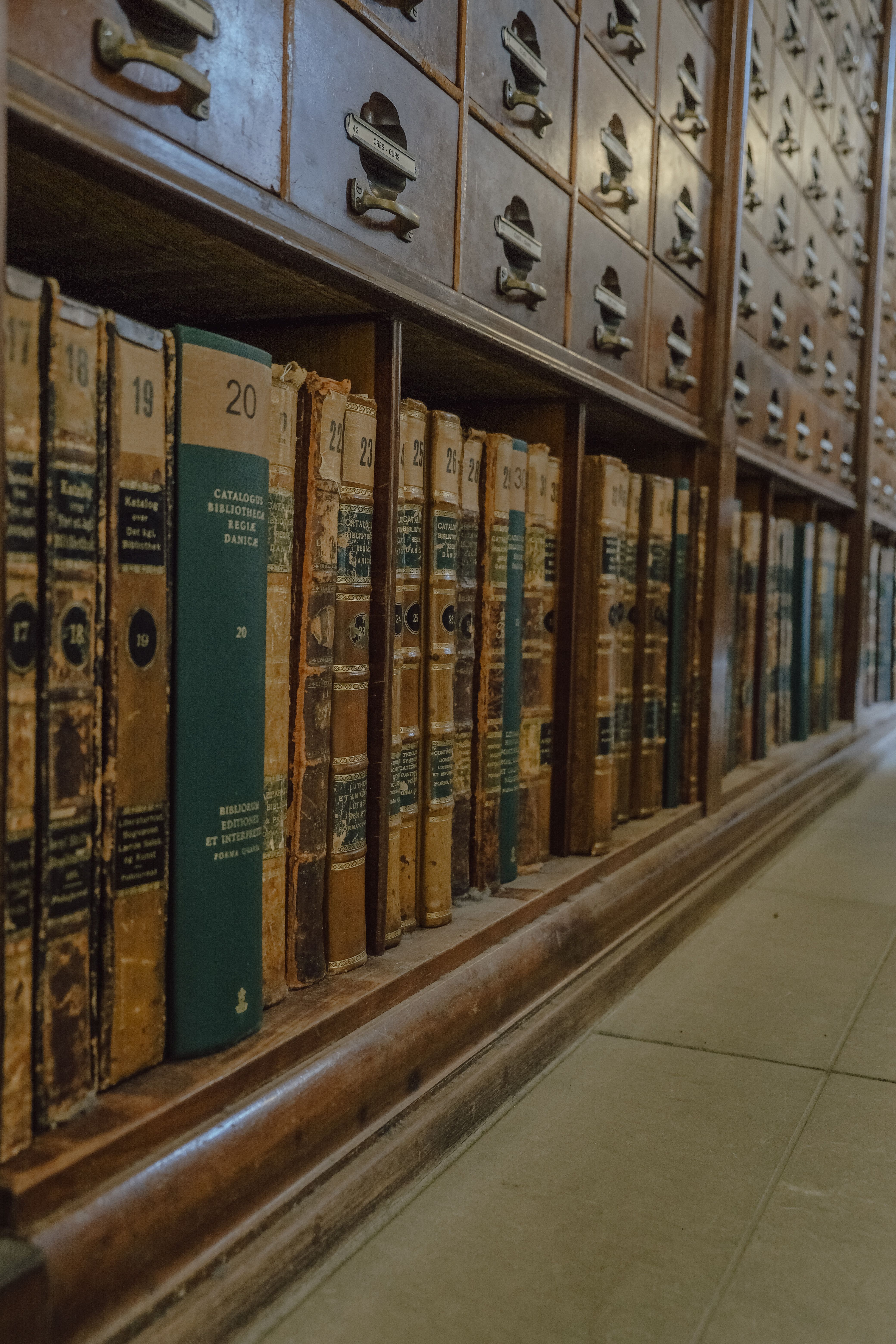 Close-up view of a classic library card catalog with vintage books.