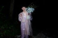 一个男人在夜晚手持鲜花，营造出梦幻般的肖像效果