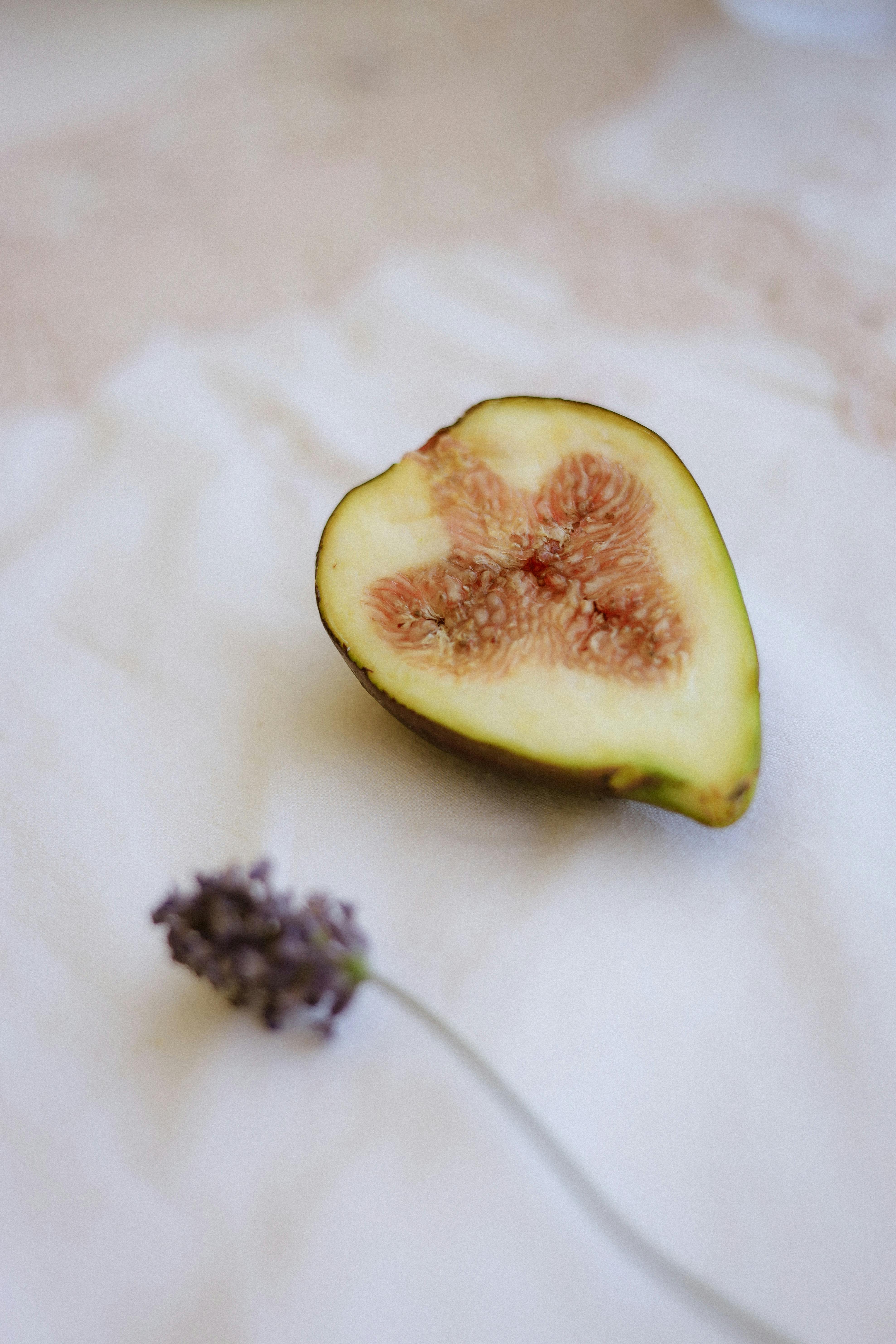 Half fig and lavender flower on white cloth, evoking a sense of calm and natural beauty.