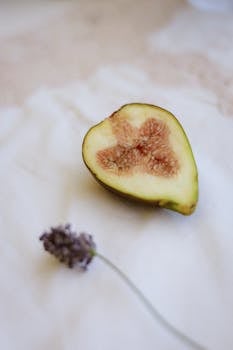 Half fig and lavender flower on white cloth, evoking a sense of calm and natural beauty.