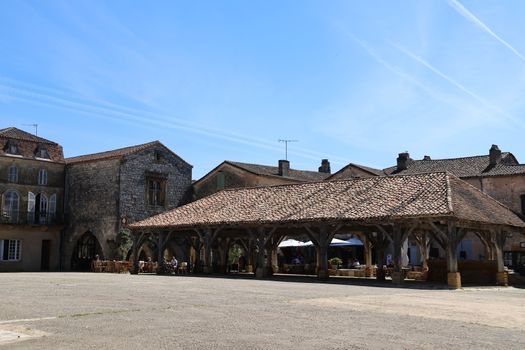 Picturesque village square with rustic architecture under a clear blue sky.