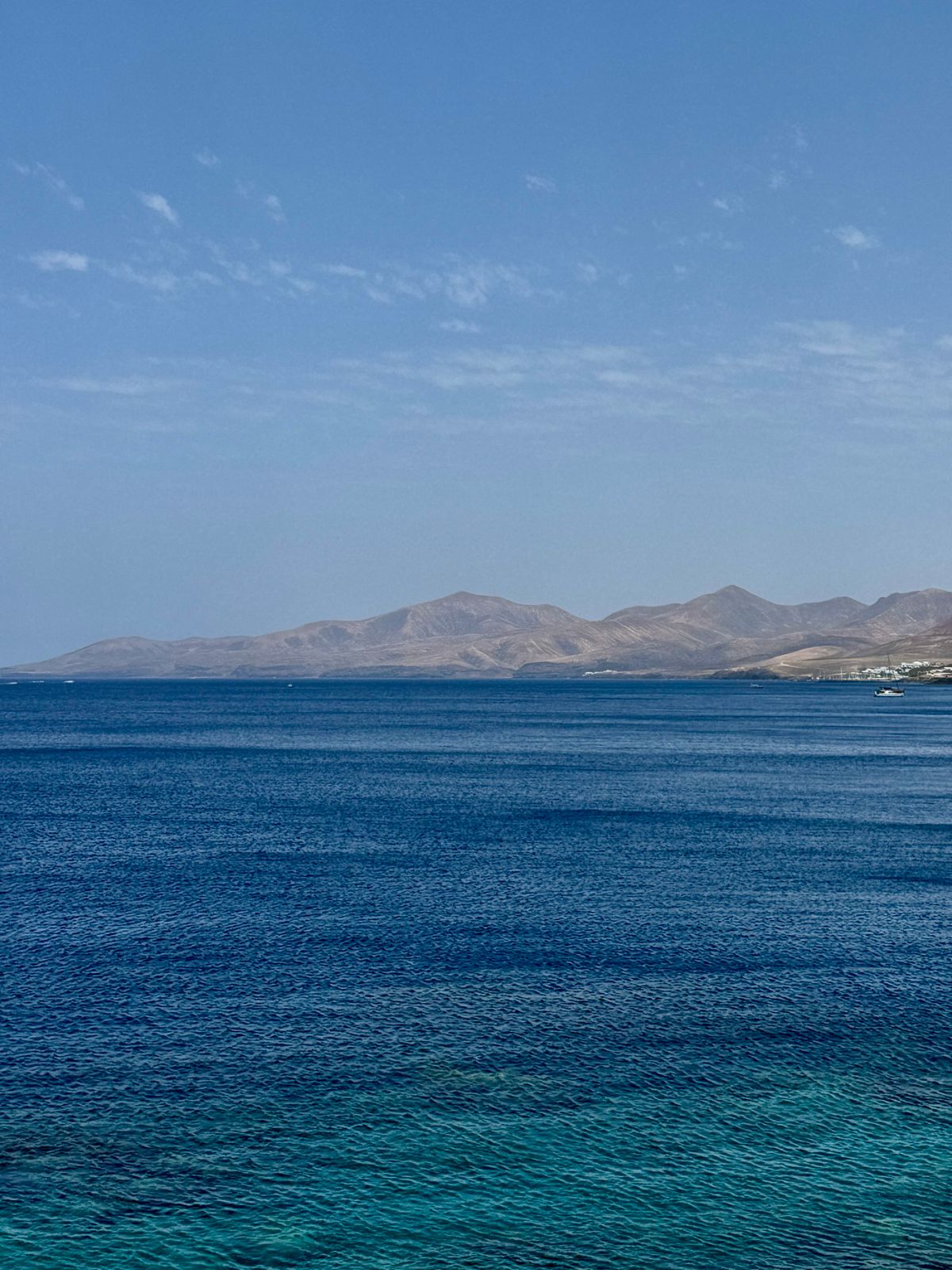 Costa de Lanzarote con mar azul y montañas al fondo