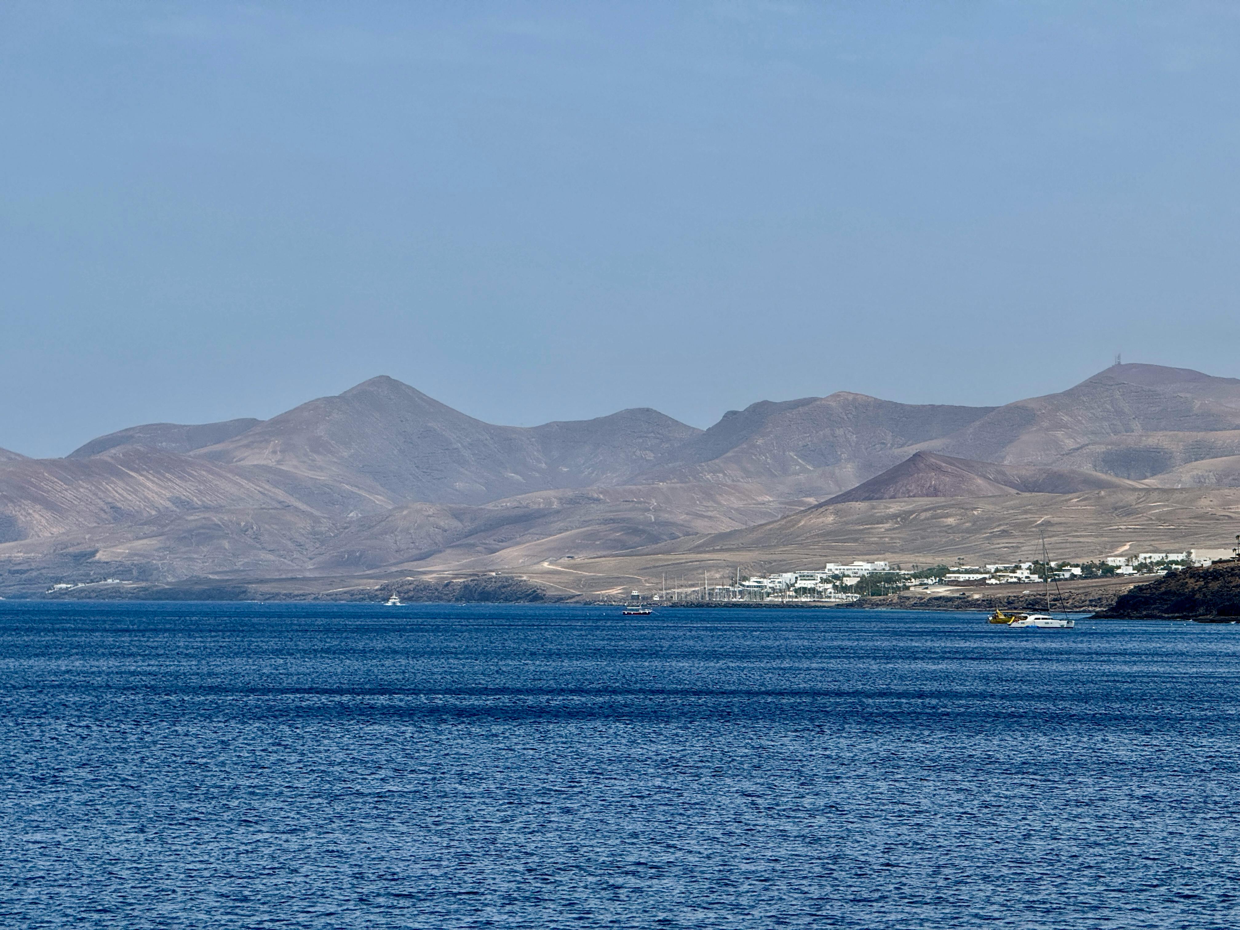 Explore the serene coastal landscape of Lanzarote, featuring stunning mountains and ocean views.