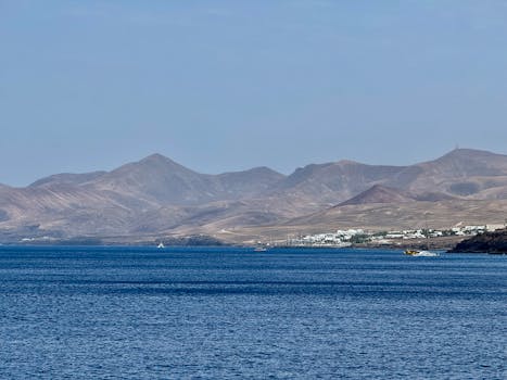 Explore the serene coastal landscape of Lanzarote, featuring stunning mountains and ocean views.