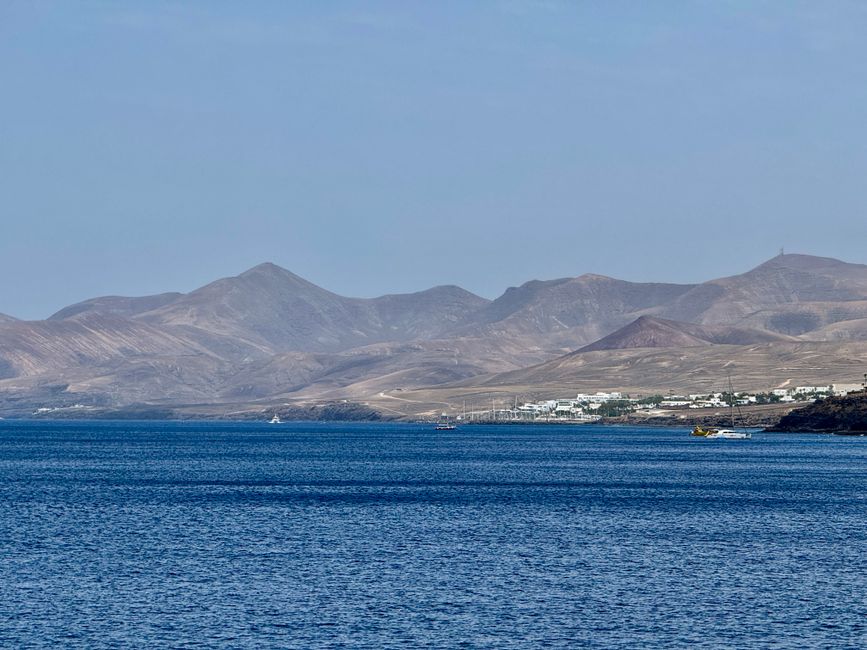 Explore the serene coastal landscape of Lanzarote, featuring stunning mountains and ocean views.
