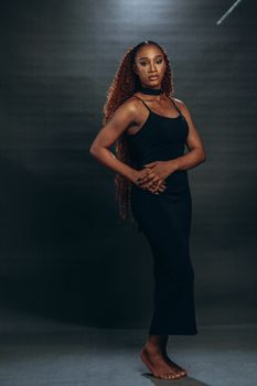 Stunning studio portrait of woman in black dress with curly hair