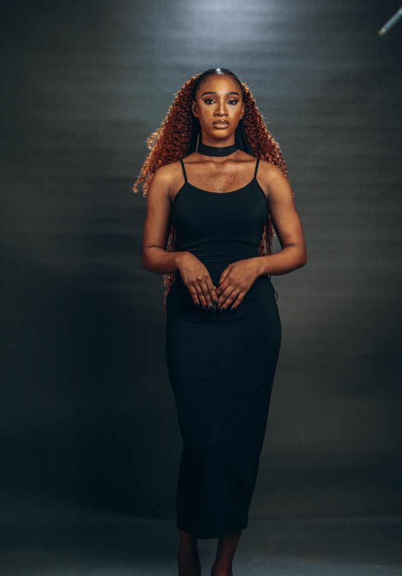 Elegant woman in a black dress with voluminous curly hair