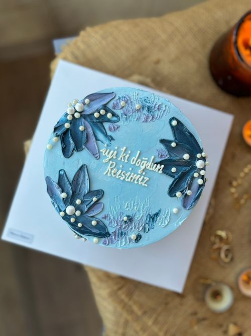 Free A beautifully decorated blue birthday cake with floral accents and a personal message on top. Stock Photo