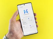 Hand holding smartphone with Funtouch OS 14