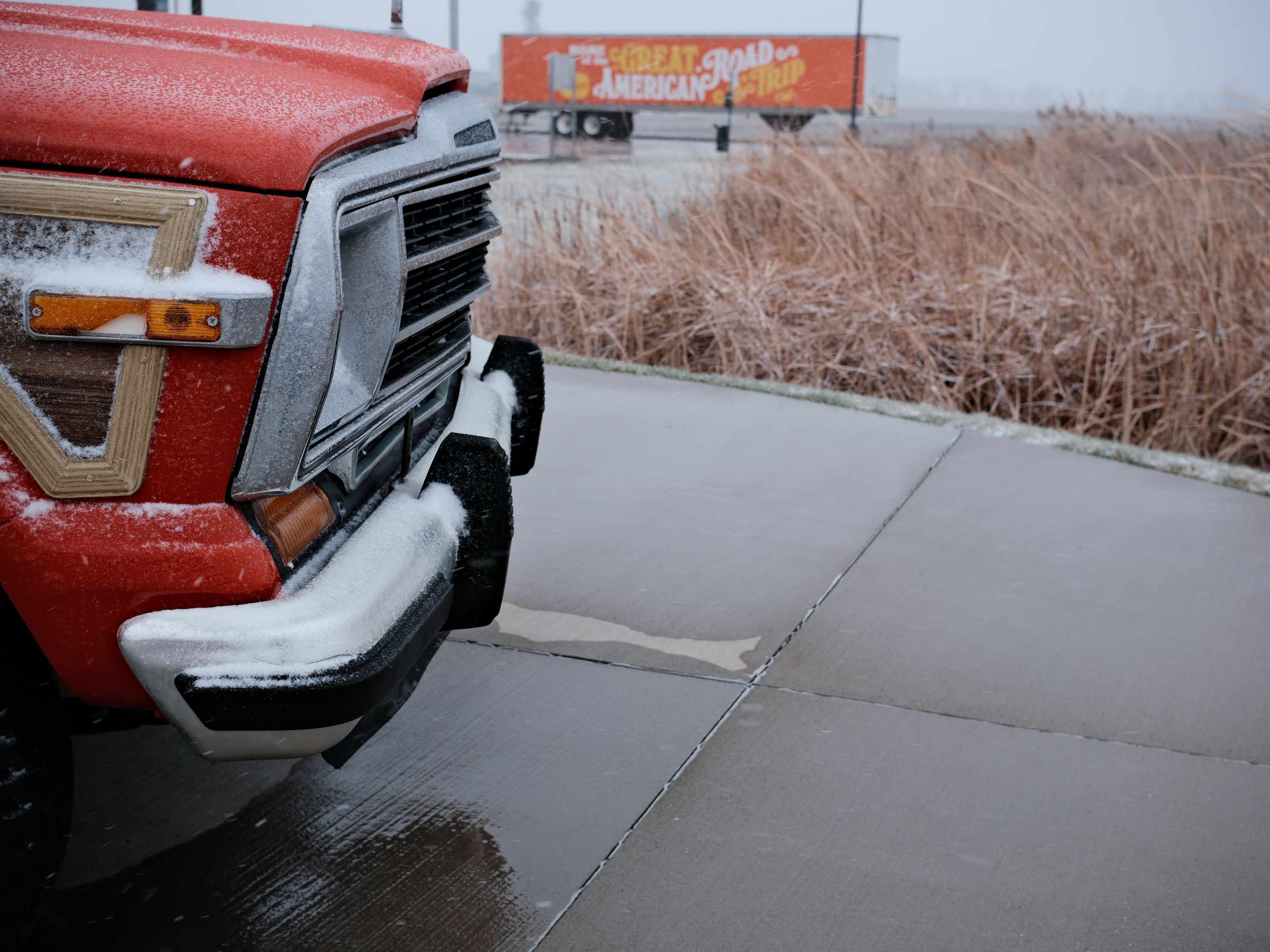 A retro vehicle dusted with snow on a snowy pavement in Pontiac, Illinois.