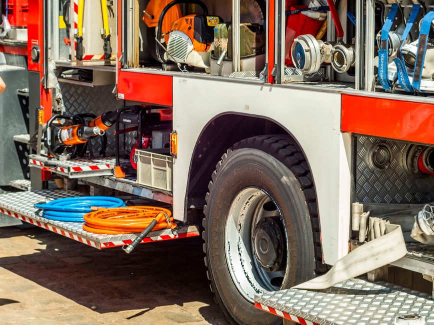 Close-up of a fire truck showcasing its equipment and tools in daylight.