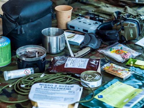 Free A diverse assortment of camping and survival items laid out, including food, tools, and gadgets. Stock Photo