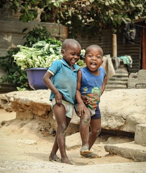 在安哥拉罗安达的户外，两个快乐的男孩正在玩耍，捕捉到了纯粹的快乐和童年的纯真时刻