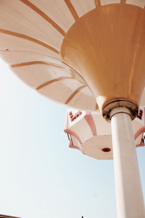 Free A stylish view of a vintage amusement park ride captured from below, showcasing bright pastel colors. Stock Photo