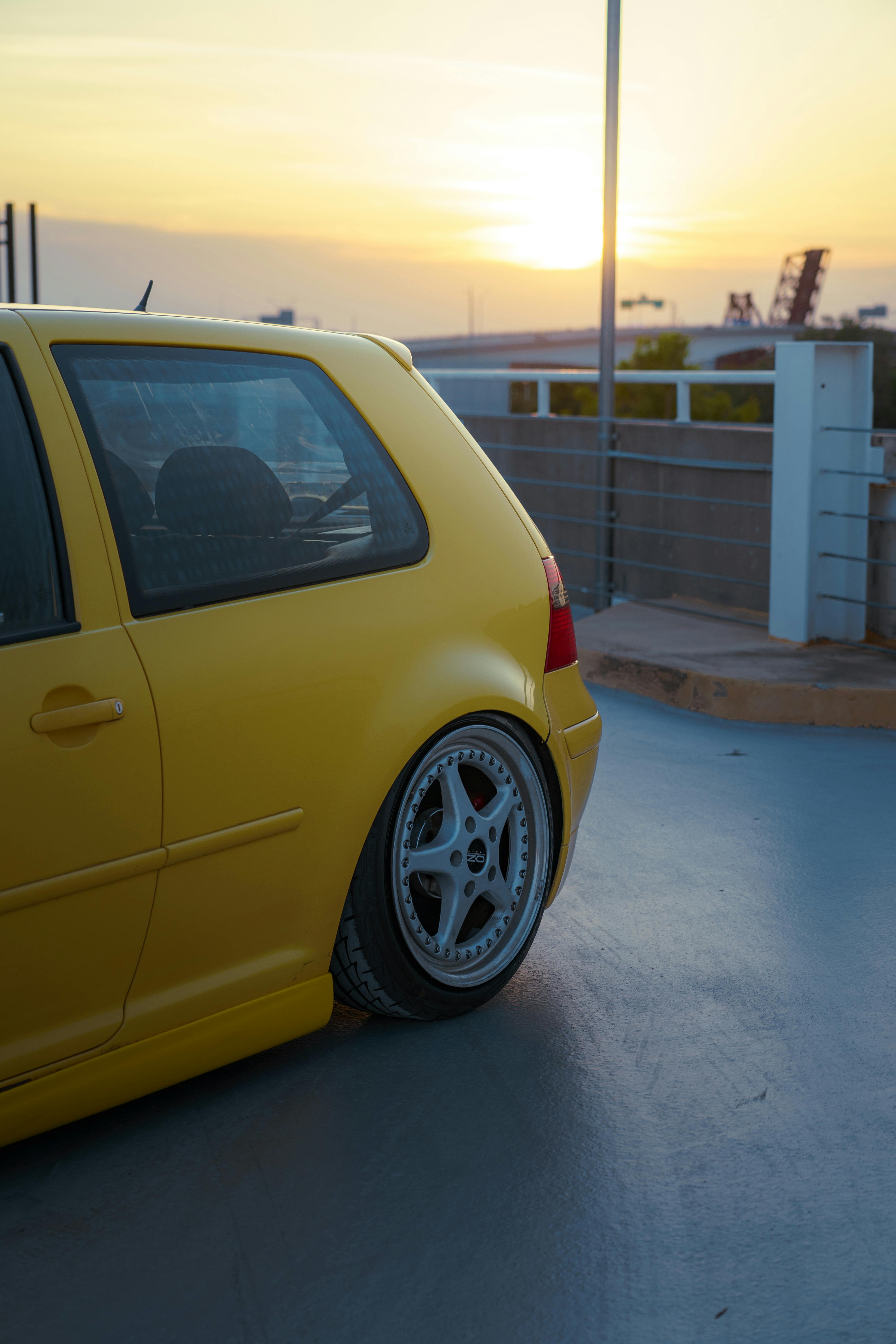 bezplatná Zářivě žluté auto zaparkované venku při západu slunce v pozadí. Základová fotografie