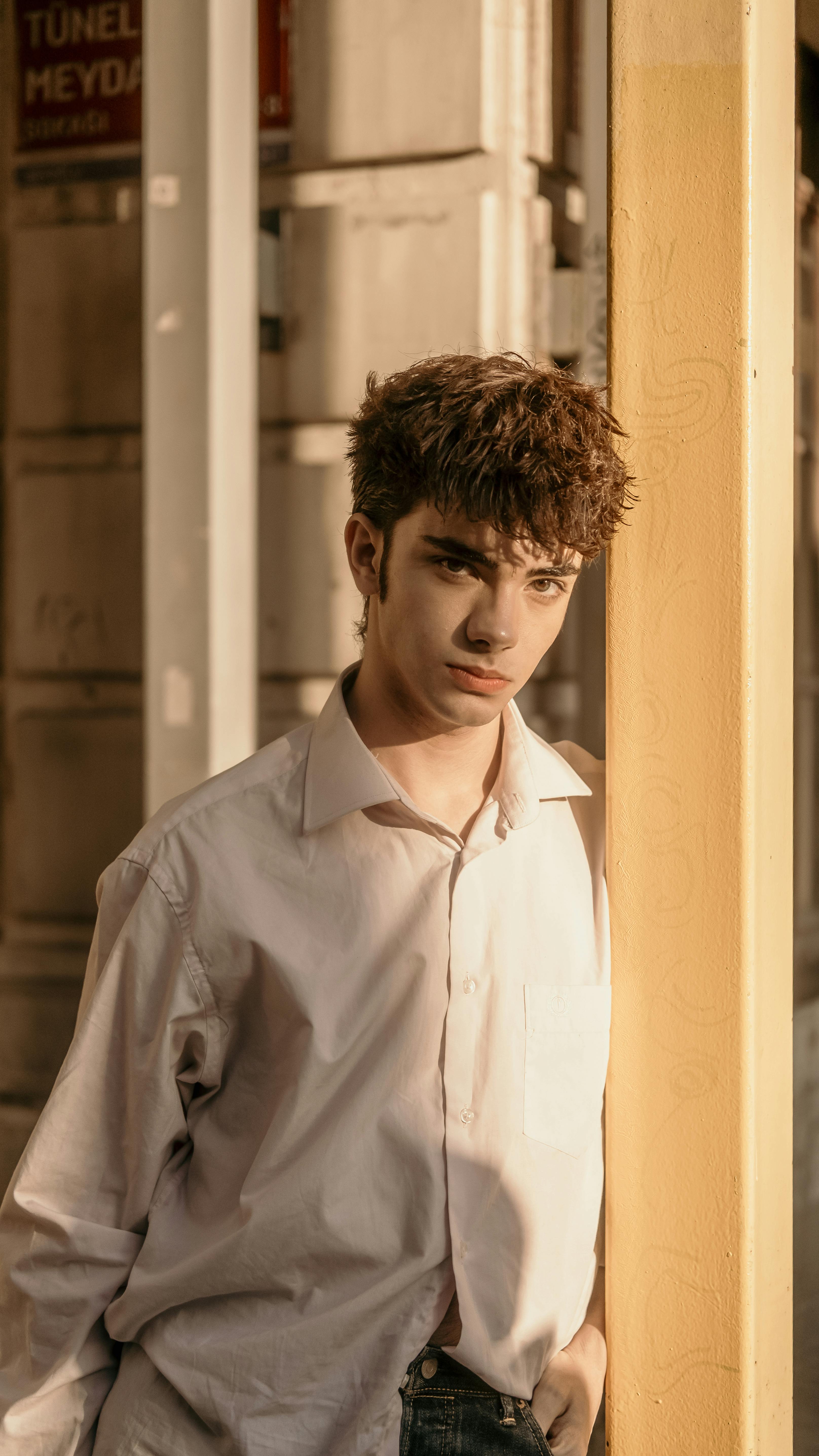 Introspective portrait of a young man leaning against a wall in Istanbul.