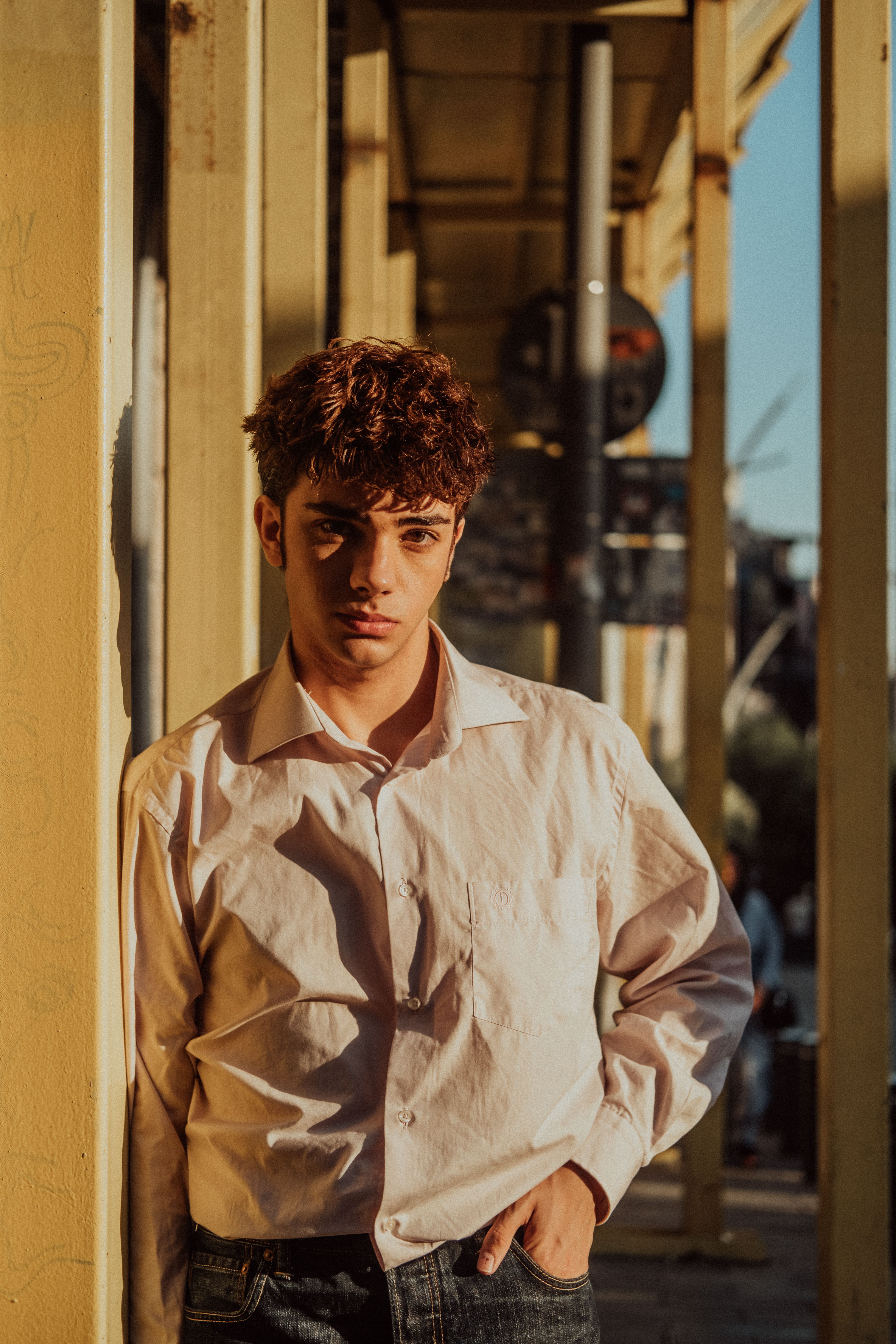 Stylish portrait of a young man in a sunny Istanbul street, capturing a relaxed urban vibe.