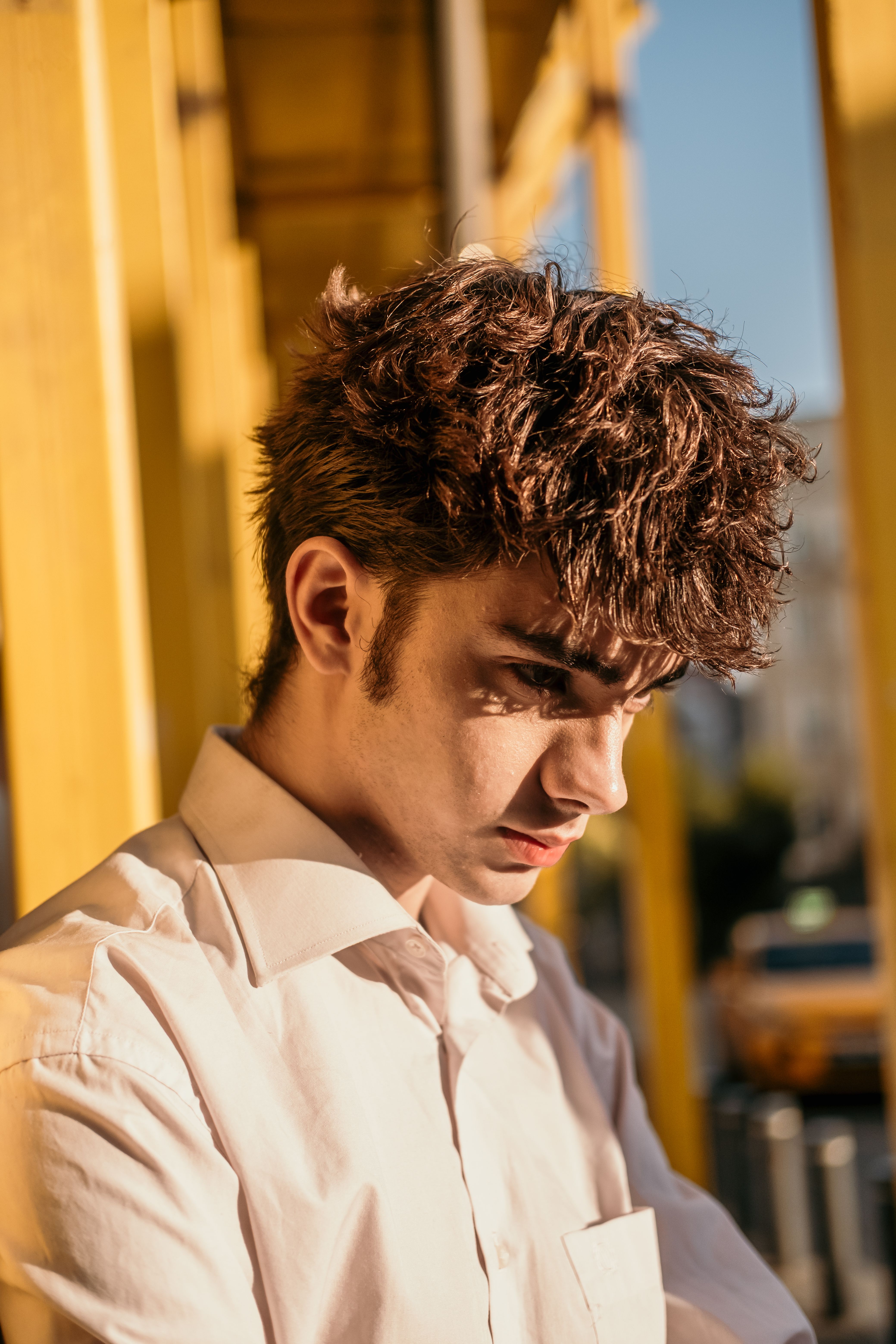 A striking portrait of a young man in İstanbul with golden sunlight casting dramatic shadows.