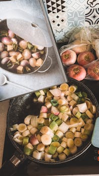 Top view of turnips and leeks cooking in a pan, with a cookbook for guidance.