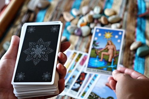 Free A close-up view of hands holding tarot cards, ideal for fortune telling or divination concepts. Stock Photo