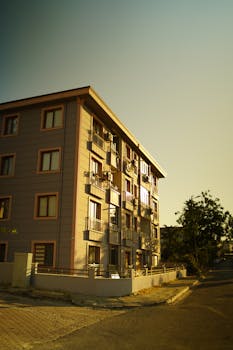 A warm-toned image of a multi-story apartment building during sunset.