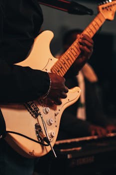 Musician performing at a live concert, focused on electric guitar play.