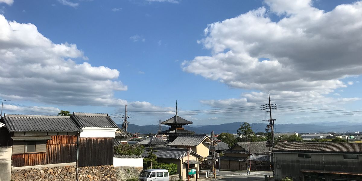 Scenic view of a traditional Japanese town featuring a pagoda under a clear blue sky.