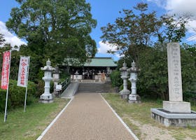 一座传统日本神社的入口宁静祥和,周围环绕着郁郁葱葱的绿色植物。