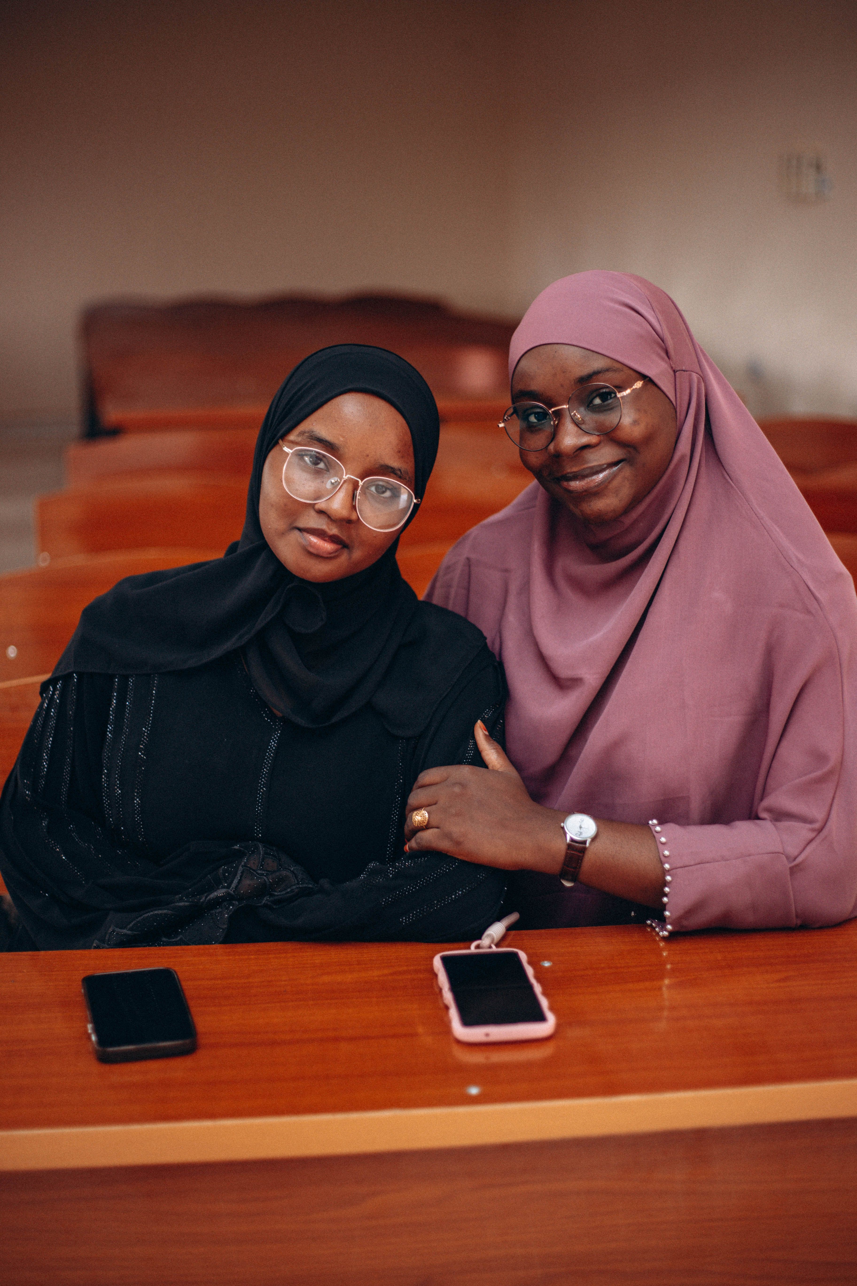 Two Women in Hijabs Sitting Together Indoors · Free Stock Photo