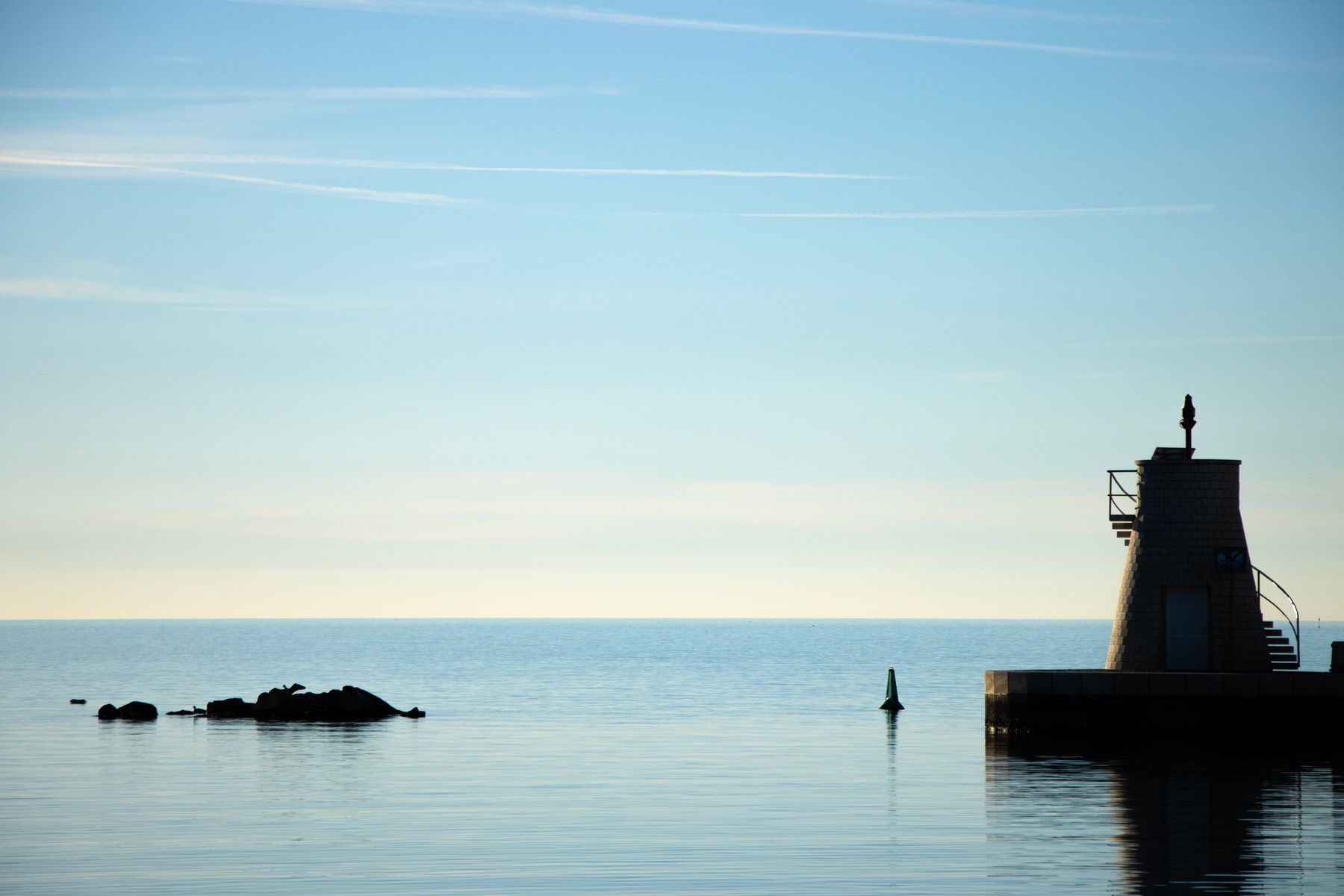 Coastal lighthouse silhouetted against the sea at dusk, photo by Eclipse Chasers on Pexels