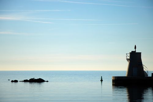 Free Serene coastal scene with lighthouse silhouetted by the Adriatic Sea in Croatia. Stock Photo