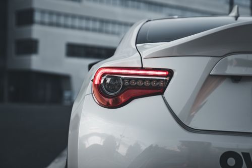 Free Stylish rear light detail of a modern white sports car parked in an urban area. Stock Photo