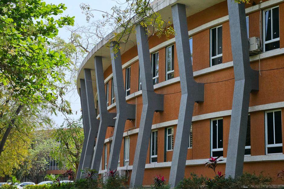 Curved modern building with distinct architectural columns in Ahmedabad, India.