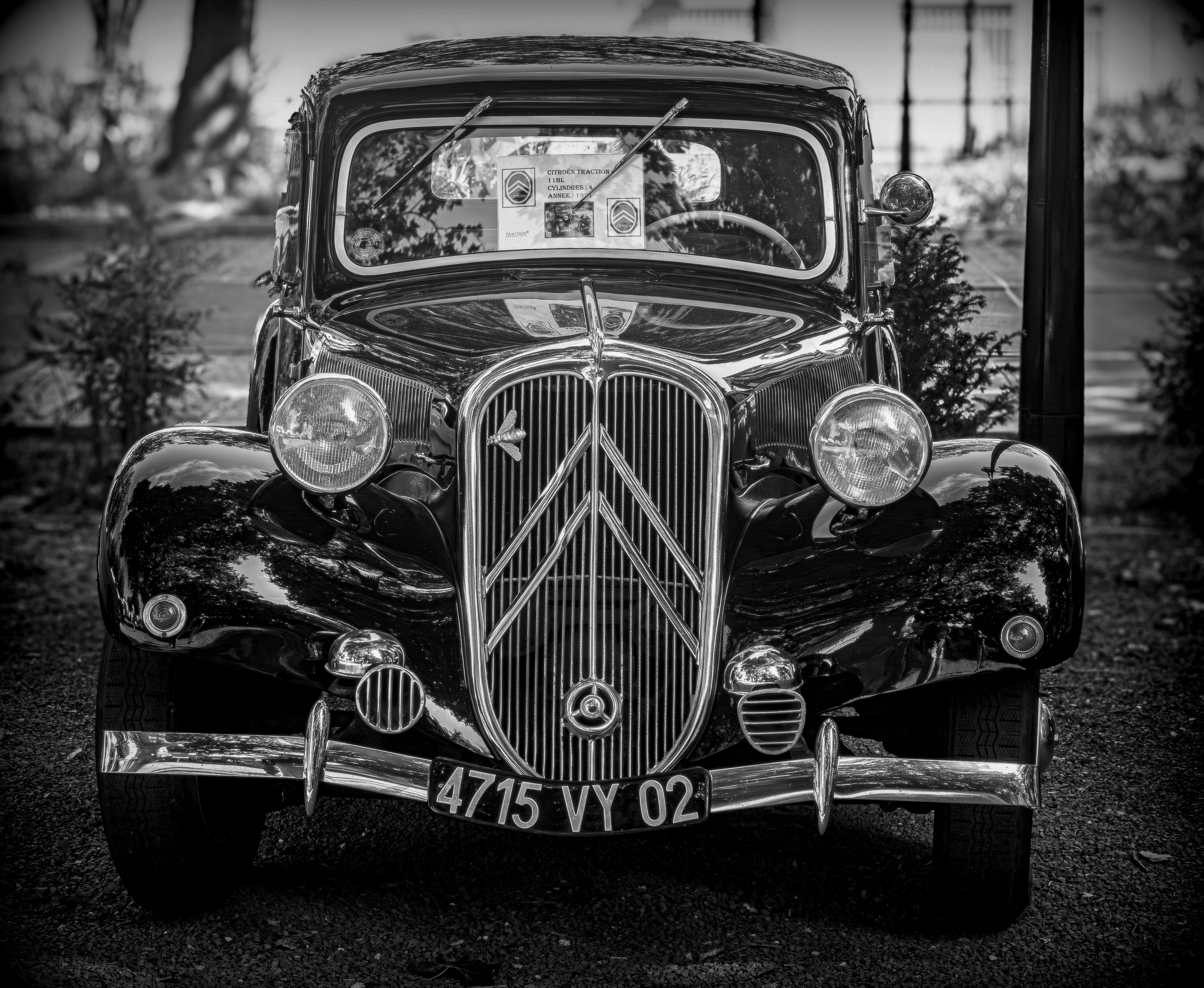 Black and white photograph of a classic vintage car from the front, showcasing its elegant design and details.