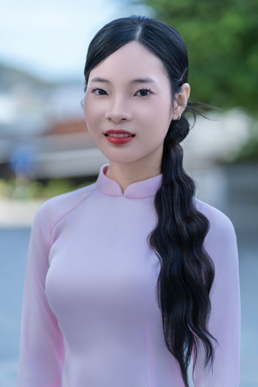 Elegant portrait of an adult woman in pink traditional dress outdoors.