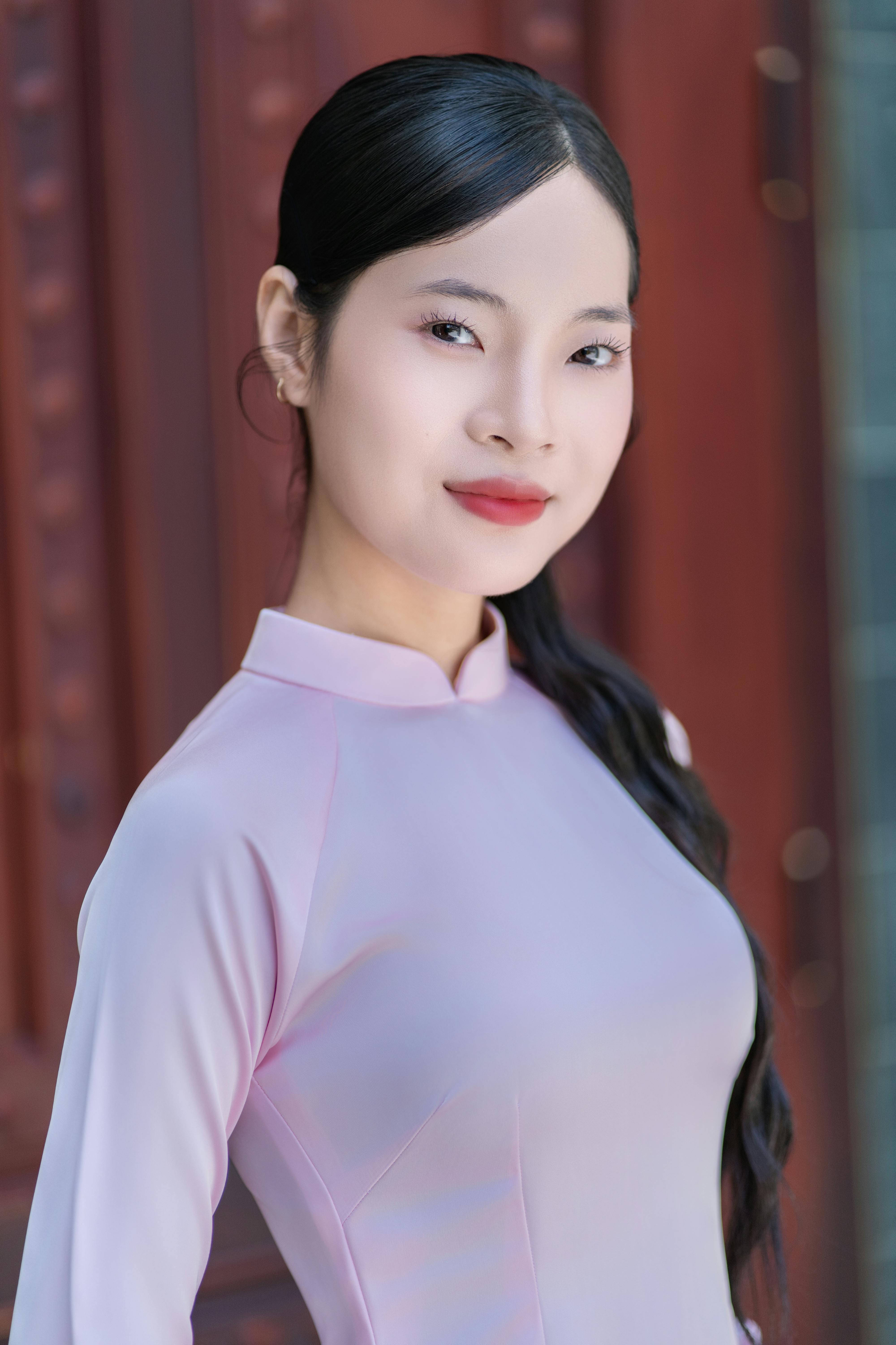 Gratis Mujer elegante con vestido tradicional rosa posando con confianza al aire libre. Foto de stock
