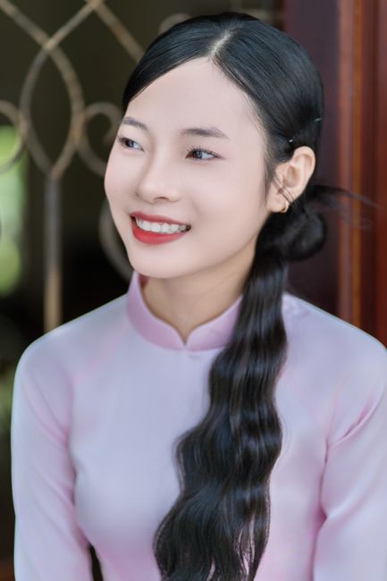 Smiling young woman in traditional garment, embodying elegance and grace.