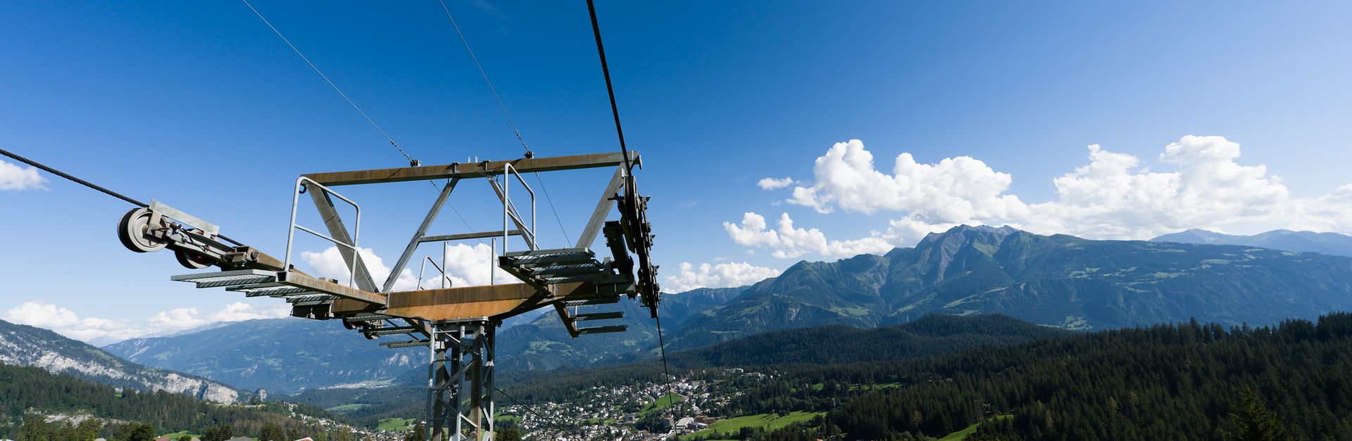 Breathtaking view of the Swiss Alps and cable car with lush landscapes and blue skies.