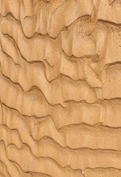 Detailed close-up of intricate sand patterns resembling waves, showcasing natural textures and earthy tones.