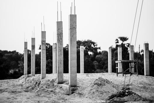 Black and white image of concrete pillars at an unfinished construction site in Faridpur, Bangladesh.
