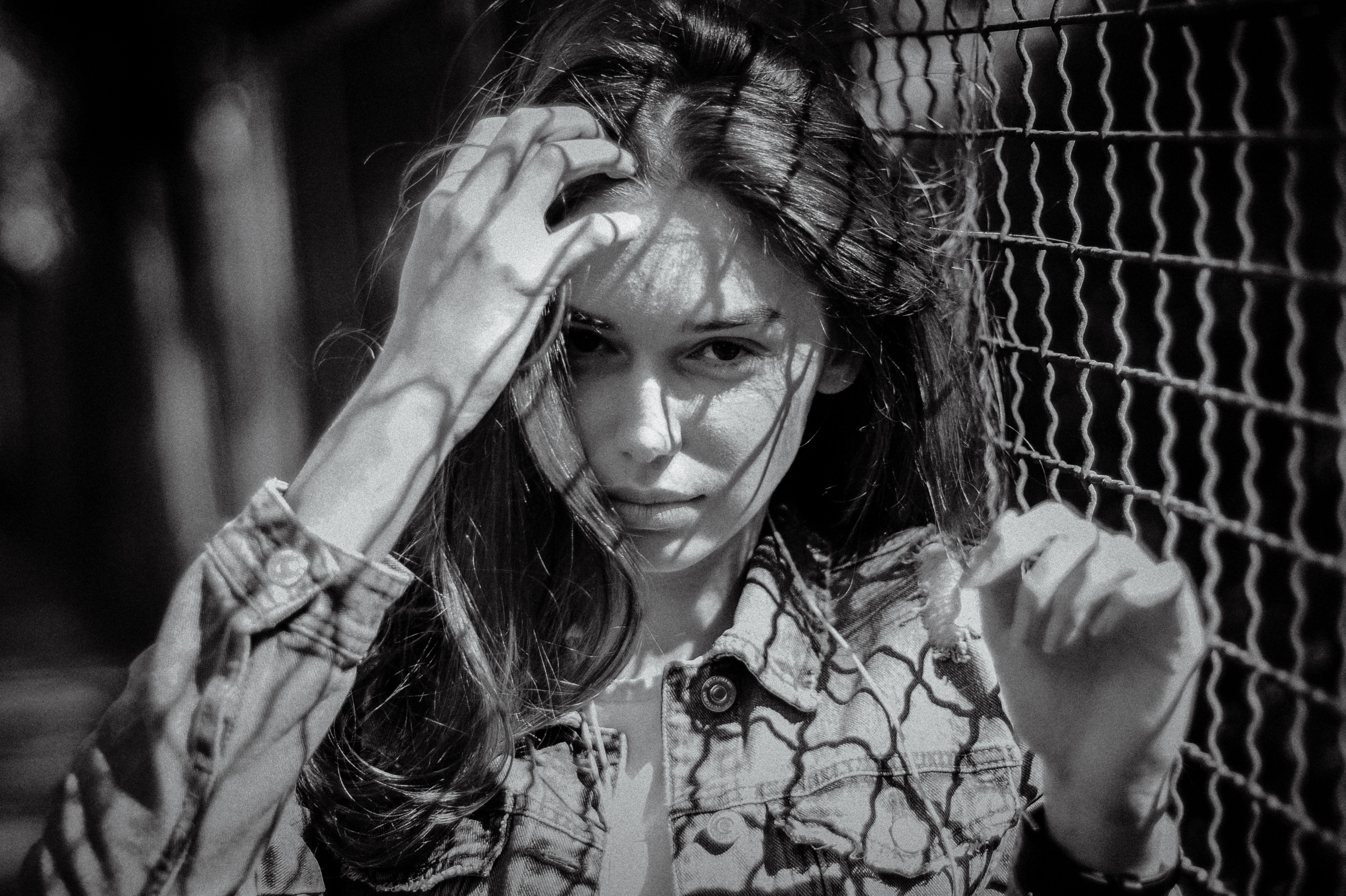 A stunning black and white portrait capturing a woman's intense gaze on a sunny day.